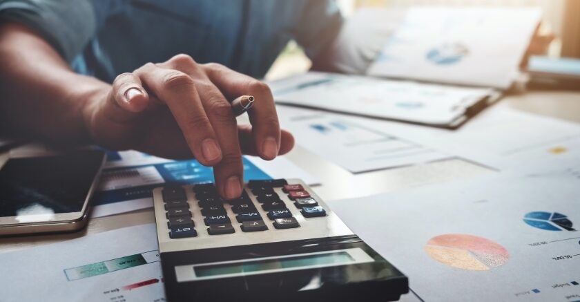 somebody working on financial reports with a calculator