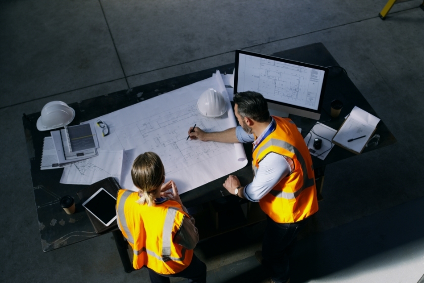 Two engineers working on blueprints