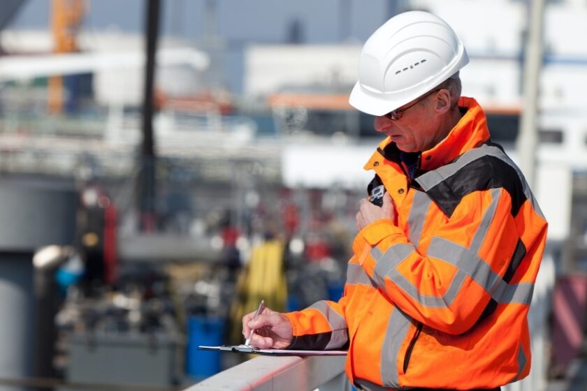 A site inspector taking notes on his clipboard